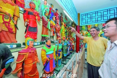 襄陽一老人在自辦的“三國人物泥塑館”為參觀者介紹自己的泥塑作品。