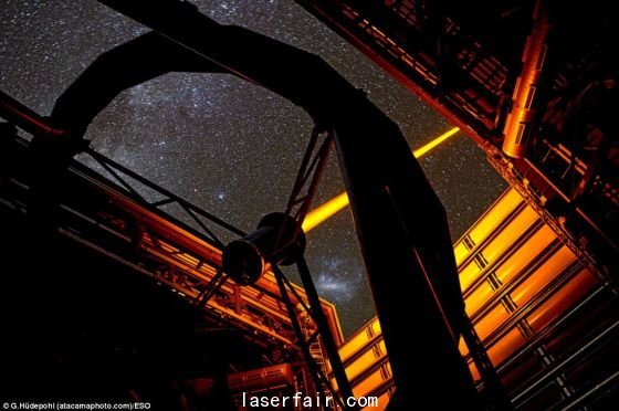 智利歐洲南方天文臺(tái)帕拉納爾天文臺(tái)操作的這個(gè)新PARLA激光器。從圖上可以看到，7瓦特激光器發(fā)出的橙黃色光束從甚大望遠(yuǎn)鏡的望遠(yuǎn)鏡4的穹隆結(jié)構(gòu)射向高空。在背景圖上還能看到大麥哲倫云