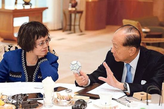 李嘉誠（右）在接受媒體訪問時指出，長實集團(tuán)以香港為基地，常常積極在港尋找投資機會，但是政府很多政策，需時消化。圖為他向財新傳媒總編輯胡舒立介紹他本周的“最愛”納米LED燈泡。圖片來源：香港明報